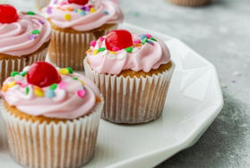 cupcakes with white icing on white ceramic plate
